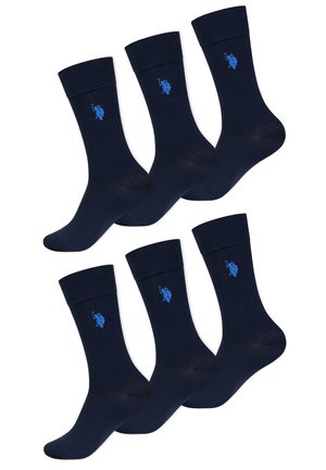 Sechs Paar marineblaue Crew-Socken mit einem kleinen hellblau gestickten Logo nahe dem oberen Bündchen jeder Socke.