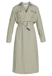 Ljust grön, långärmad klänning med inslaget design, två bröstfickor, midjebälte och en mjuk tygkänsla. Har en kavajkrage.