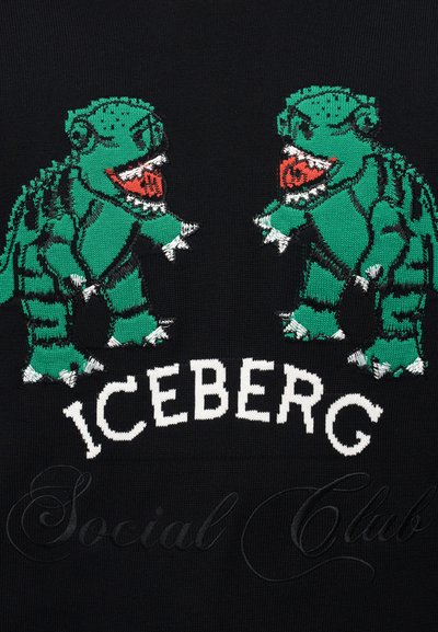 Δύο πράσινοι κινούμενοι δεινόσαυροι κοιτάζονται μεταξύ τους πάνω από τη λέξη «ICEBERG» σε μαύρο ύφασμα με αχνό καλλιγραφικό κείμενο από κάτω.