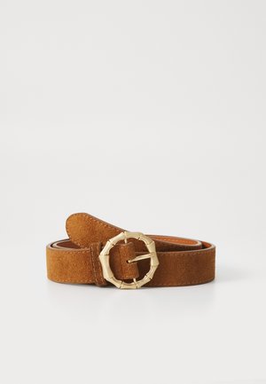 Bruine suède riem met een gouden ronde gesp en stikdetails; gladde textuur met een ronde punt en verstelbare lengte.