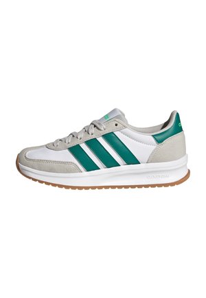 Baskets blanches et grises avec des bandes vertes Adidas et un languette au talon, lacets gris, semelle intermédiaire blanche et semelle extérieure couleur gomme sur fond blanc.