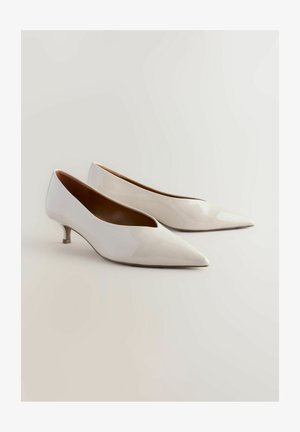 Vita patenterade läderpumps med spetsig tå och liten kittenklack, med en slät yta och minimalistisk design.