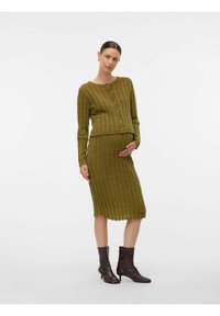 Maslinasto zelena rebrasta pletena kombinacija, koja se sastoji od kardigana na kopčanje s dugim rukavima i suknje do koljena. Izrađena je od teksturiranog materijala.