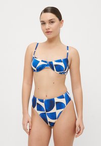 Kék és krém mintás bikini szett, amelynek a teteje strukturált, állítható pántokkal, míg az alja magas derekú, mindkettő sima anyagból készült.