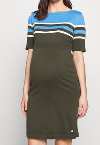Abito in maglia con parte superiore blu a righe orizzontali bianche e verdi, sezione inferiore verde attillata e maniche corte.