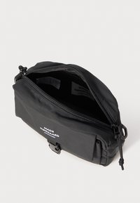 Black nylon bag with a zip closure, featuring a compact rectangular design. Includes a logo printed in white on the front.