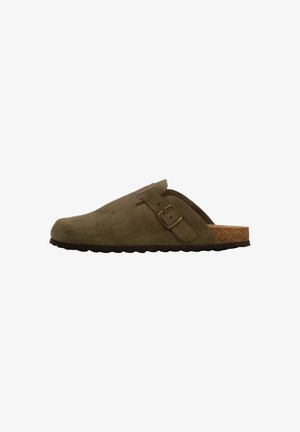 Sabots en suede vert olive avec une semelle en liège, dotés d'une sangle latérale et d'une boucle. Design minimaliste avec un bout arrondi et une finition texturée.