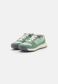 Grüne Sneaker aus Wildleder und Nylon, mit weißen Schnürsenkeln, einer grauen Gummisohle und einem gepolsterten Schaft. Mit dreieckigen Einsätzen akzentuiert.