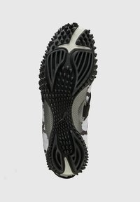 Zwart-wit camo sport-schoenzool met prominente grip-noppen, rubbermateriaal, gestructureerd oppervlak en een flexibel ontwerp.