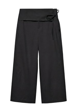 Pantalon noir à jambes larges avec une taille haute repliée et une fine ceinture nouée sur le côté droit.