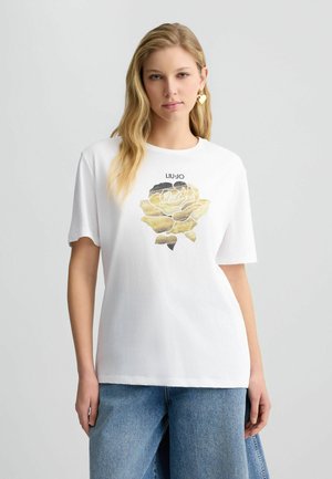 Witte katoenen T-shirt met een tekst- en grafisch ontwerp van een gele roos met zwarte accenten. Comfortabele pasvorm met korte mouwen en ronde halslijn.