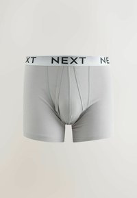 Boxer homme gris clair avec logo noir "NEXT" sur la ceinture blanche, poche avant et coutures visibles.