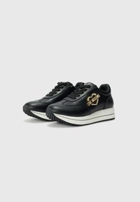 Zwarte leren sneakers met een gladde afwerking, voorzien van een witte middenzool, zwarte rubberen buitenzool en een gouden hartlogo aan de zijkant.