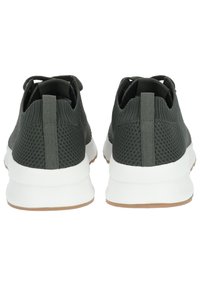Zapatillas deportivas de color verde oscuro con parte superior de malla texturizada, media suela blanca y suela de goma. Cuentan con lengüetas en la parte posterior para facilitar el uso.