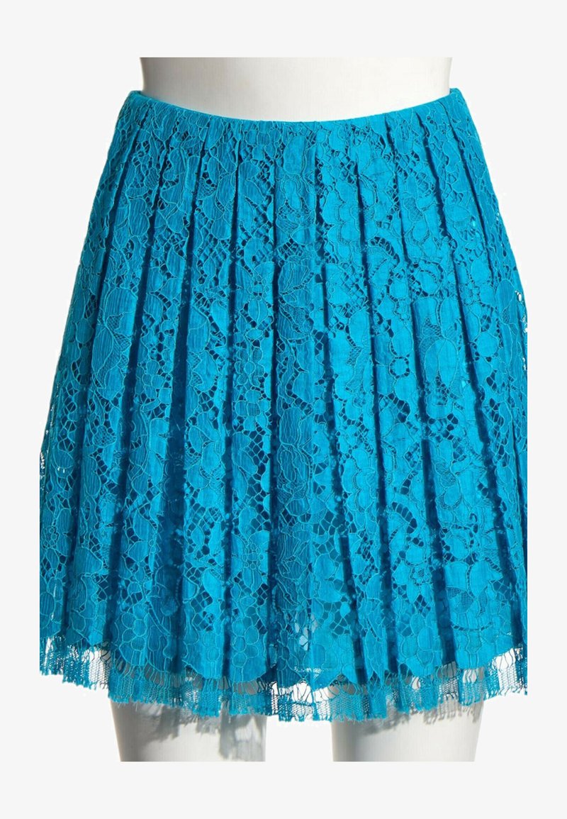 Jupe plissée bleu vif avec superposition de dentelle florale, longueur genou, présentée sur un torse de mannequin blanc.