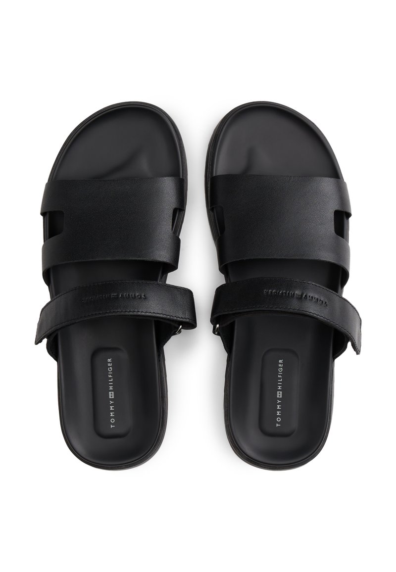 Sandalias negras con diseño abierto, hechas de material sintético liso con dos correas anchas y planas. Logo notable en la plantilla.