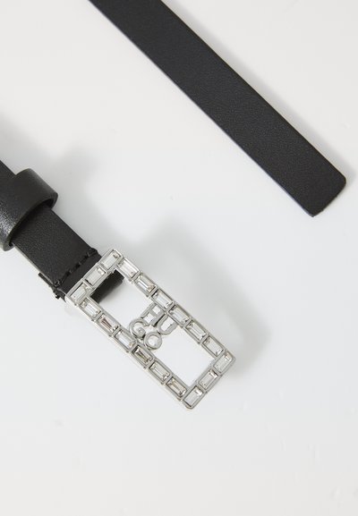 Ceinture en cuir noir avec une boucle rectangulaire en acier argenté décorée de cristaux transparents et le lettrage "HUGO" au centre sur fond blanc.