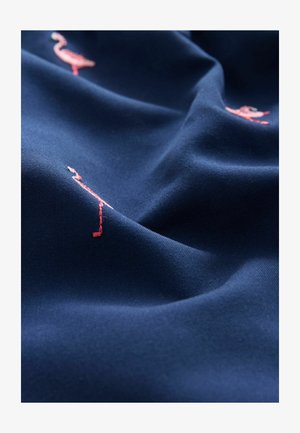 Námorná tkanina s detailným vyšívaním ružových plameniakov, s jemnou štruktúrou a hladkým povrchom. Prvky zahŕňajú malé detaily čierneho zobáka.