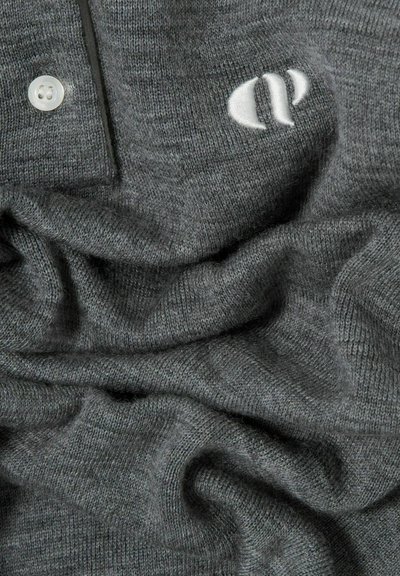 Tessuto a maglia grigio con una morbida texture, presenta un logo bianco e un dettaglio a bottone. Il tessuto è disegnato in modo sciolto, evidenziando il suo drappeggio.