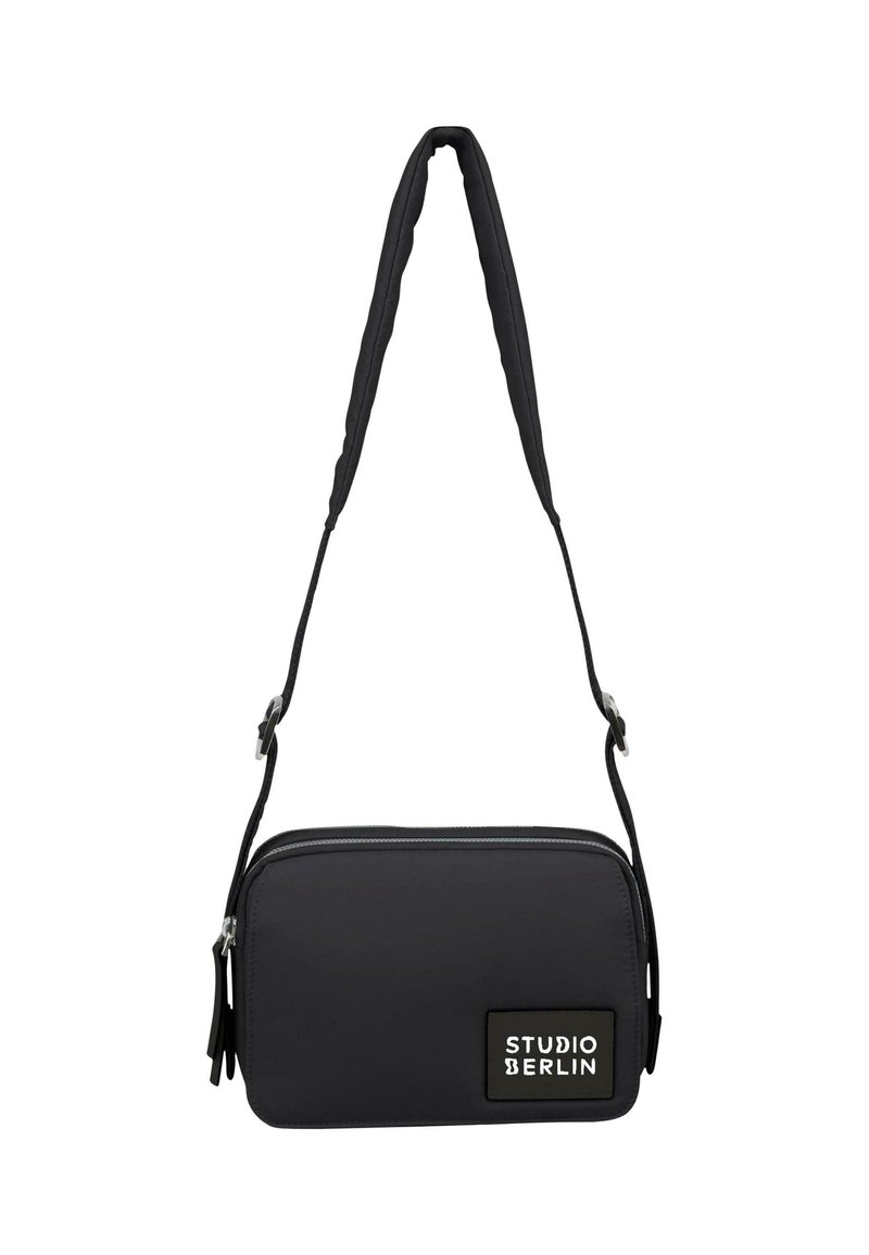 Borsa a tracolla nera realizzata in materiale resistente. Presenta una superficie testurizzata, una chiusura con zip e un'etichetta di marca. Inclusa una tracolla regolabile.