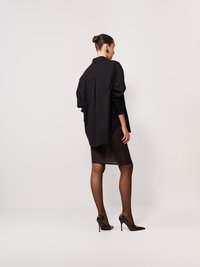 Fekete, oversized ing gallérral, barna, testhez simuló szoknyával, áttetsző barna harisnyával kiegészítve, hegyes orrú magassarkú cipővel.