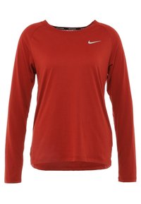 Maglia sportiva a maniche lunghe rossa realizzata in tessuto leggero, con collo rotondo e un piccolo logo Nike argentato sul davanti.