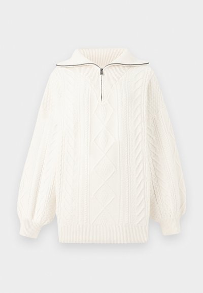 Jersey blanco de punto con cuello de media cremallera, que presenta patrones texturizados, diseños de trenzado y mangas acampanadas de gran tamaño.