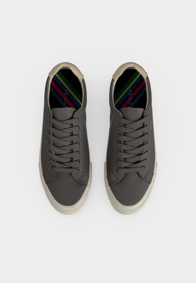 Paire de baskets lacées gris foncé avec semelles blanches et semelles intérieures rayées multicolores, vues de dessus sur fond blanc.