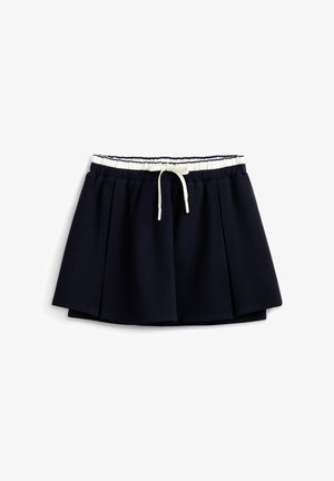 Falda plisada azul marino con cintura elástica blanca y cordón delantero, mostrada sobre un fondo blanco.