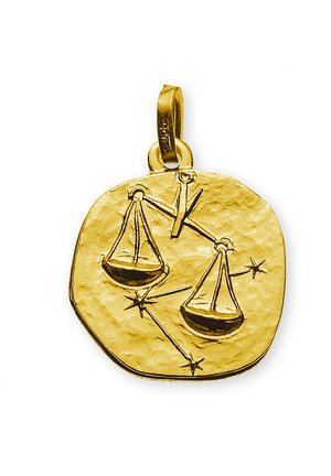 Pendente in oro con texture martellata, che illustra bilance e stelle, di forma circolare e con un anello per il fissaggio.