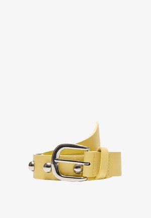 Rumeni usnjeni pas z okroglimi srebrnimi zakovicami in srebrno kovinsko sponko, prikazan zvit na belem ozadju.