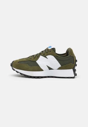 Olivgrüner und weißer Sportschuh mit Wildleder-Overlays, dicker weißer Mittelsohle, schwarzer robuster Außensohle und großem weißem N-Logo an der Seite.