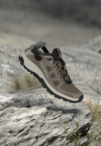 Ελαφρύ πεζοπορικό παπούτσι σε ταμπά χρώμα με επάνω μέρος από δίχτυ, μαύρες λεπτομέρειες και υφασμένο λαστιχένιο πάτο. Διαθέτει ρυθμιζόμενο λουράκι και λαβές πρόσφυσης για καλύτερο κράτημα.