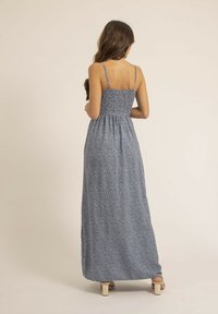 Robe maxi avec bretelles spaghetti réglables ; tissu bleu avec de petits motifs blancs ; corsage ajusté avec jupe froncée.