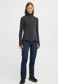 Long-sleeve charcoal pullover with half-zip and stand collar paired with navy cargo pants featuring side pockets and knee patches. Black footwear.