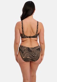 Zwart en beige bikini set met een golvend patroon. Heeft verstelbare bandjes, een haaksluiting op de achterkant van de top, en een hoogtaille onderstuk.