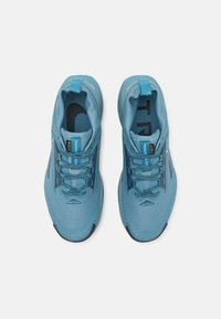 Chaussures de sport bleues avec un tige en maille respirante, un design texturé, un renfort au niveau des orteils et des lacets réglables.