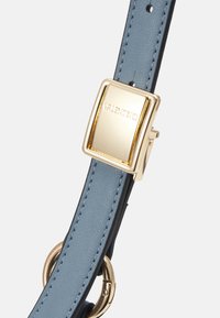 Ανοιχτό μπλε δερμάτινο λουράκι με χρυσή ορθογώνια αγκράφα και κυκλικά μεταλλικά αξεσουάρ. Λείος υφασμάτινος ιστόγραμμα με αντίθετα λεπτομερώς ραμμένα.