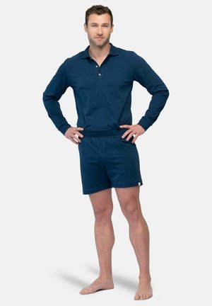 Marineblauwe longsleeve shirt met een polokraag en knoopdetail, gecombineerd met bijpassende shorts. Gemaakt van zachte, gladde stof.