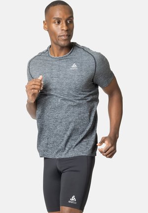 Grey textured short-sleeve athletic shirt paired with black tight-fitting shorts, featuring a logo on the left leg and smooth fabric.
