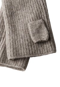 Ribbet uldscarf i lys brun med en struktureret finish. Har et lille, kvadratisk stofmærke på den ene side for ekstra detaljer.