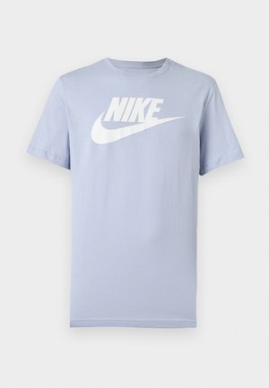 T-shirt en coton bleu clair à manches courtes avec logo Nike blanc et swoosh sur la poitrine, présenté sur un fond uni.