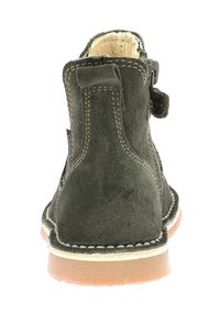 Stivaletto in camoscio verde con punta arrotondata, suola in gomma marrone, cuciture esposte e cerniera laterale per la chiusura.