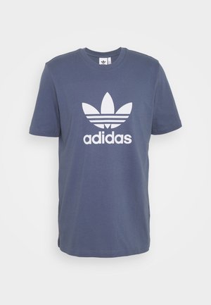 Blauw Adidas T-shirt met korte mouwen met wit trefoil-logo en de tekst "adidas" gecentreerd aan de voorkant.