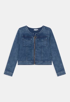 Veste en denim bleu courte avec manches longues, encolure ronde, fermeture éclair à l'avant avec tirette en anneau, et deux poches poitrine à rabat.