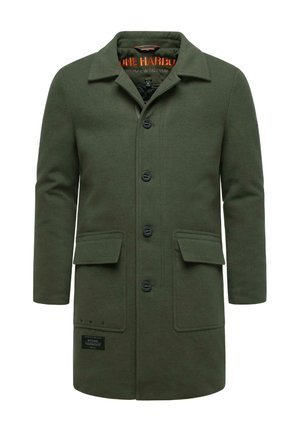 Zaļš vilnas mētelis ar apkakli, sešām melnām pogām, divām priekšējām kabatām un etiķeti apakšējā pusē. Gluda tekstūra un līdz ceļiem garš dizains.