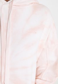 Růžová mikina s kapucí vyrobená z měkké bavlny. Má přední zip, klokánkovou kapsu a vyšívané logo "Levi's" na prsou.