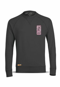 Zwarte sweatshirt met een ronde hals en raglanmouwen. Bevat een roze ticketafbeelding aan de voorkant en een klein geweven label aan de zoom.