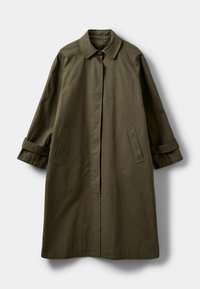 Olíva zöld, térd hosszúságú trench coat, széles gallérral, gombos záródással és oldalsó zsebekkel. Simára szabott anyag, felgöngyölített mandzsettákkal.