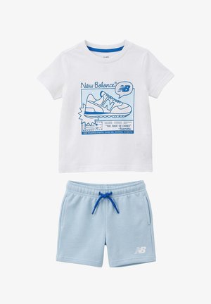T-shirt bianca a maniche corte con grafica di sneaker blu e testo abbinata a pantaloncini azzurri chiari con coulisse e logo New Balance.